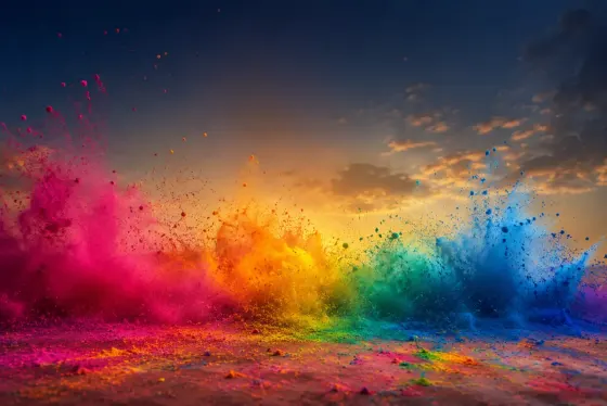 Bursts of colourful Holi powder in the air against a soft sky